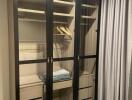 Bedroom closet with glass-paneled doors and storage drawers