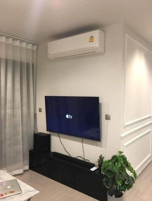 Modern living room with wall-mounted TV and air conditioner