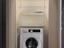 Compact laundry area with a Hitachi washing machine and shelving