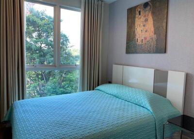 Bedroom with large window and teal bedding