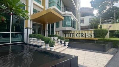 Exterior view of a modern building with landscaping, water features, and a sign reading 