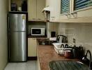 Modern kitchen with stainless steel appliances and overhead cabinets