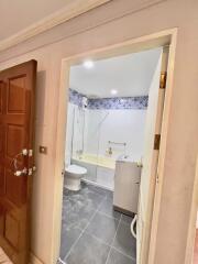 Entryway view of a bathroom with tile walls and floor