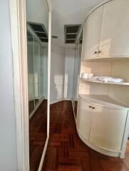 Bedroom with wooden floors, mirrored closet doors, and built-in shelving unit