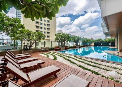 Modern residential outdoor pool area with loungers and greenery