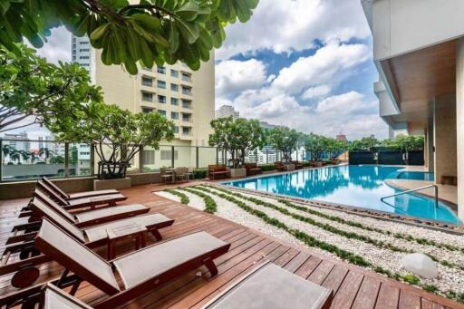 Modern residential outdoor pool area with loungers and greenery