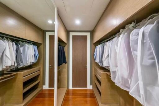 Spacious walk-in closet with wooden shelves and ample hanging space