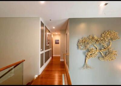 Decoratively lit hallway with wall art and wooden flooring