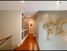 Decoratively lit hallway with wall art and wooden flooring