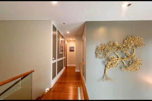 Decoratively lit hallway with wall art and wooden flooring