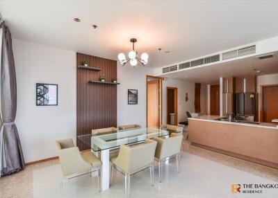 Modern dining area with glass table and kitchen