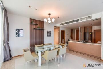 Modern dining area with glass table and kitchen