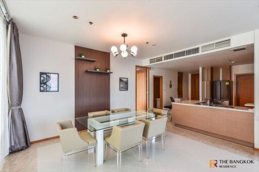 Modern dining area with glass table and kitchen