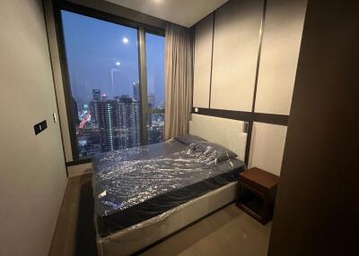 Modern bedroom with a large window view of the city