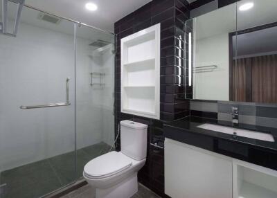 Modern bathroom with glass shower, toilet, and sink