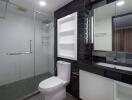 Modern bathroom with glass shower, toilet, and sink