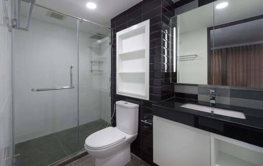 Modern bathroom with glass shower, toilet, and sink