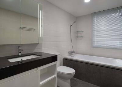 Modern bathroom with sink, toilet, bathtub, and mirror