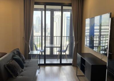 Living room with a view of the cityscape through large windows and a small balcony