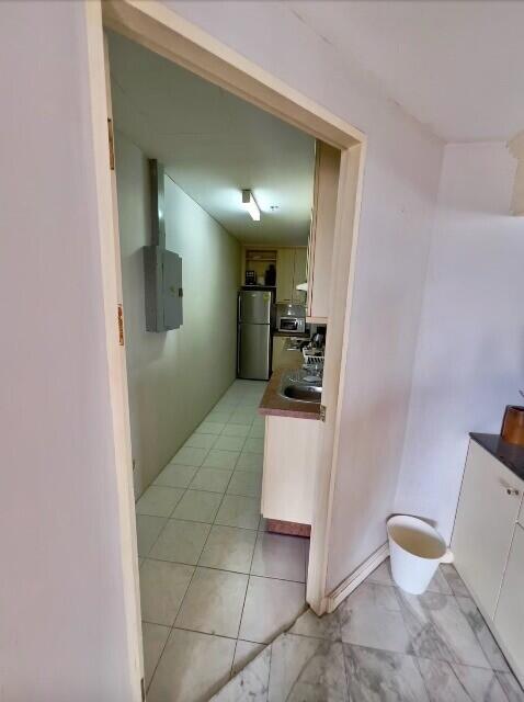 Kitchen area with sink, counter, and fridge