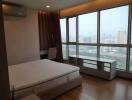 Spacious bedroom with large windows and a city view