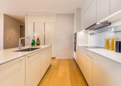 Modern kitchen with island, white cabinets, and wooden floor