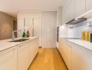 Modern kitchen with island, white cabinets, and wooden floor