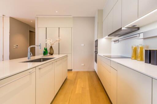 Modern kitchen with island, white cabinets, and wooden floor