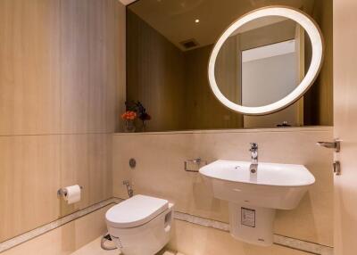 Well-lit modern bathroom with a wall-mounted sink and toilet