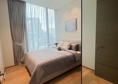 Modern bedroom with wooden flooring and large window