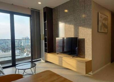 Modern living room with a TV, large window, and city view