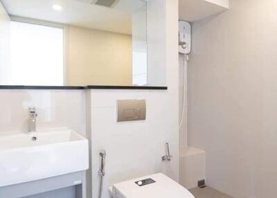 Modern bathroom with toilet, sink, and shower area