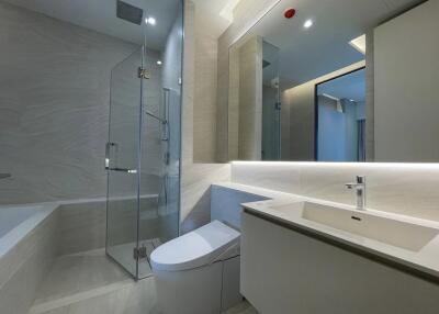 Modern bathroom with large mirror, toilet, and walk-in shower