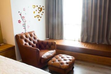 Cozy bedroom with leather armchair and decorative wall art