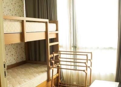 Bedroom with bunk bed and a drying rack near a window