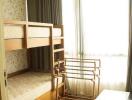 Bedroom with bunk bed and a drying rack near a window