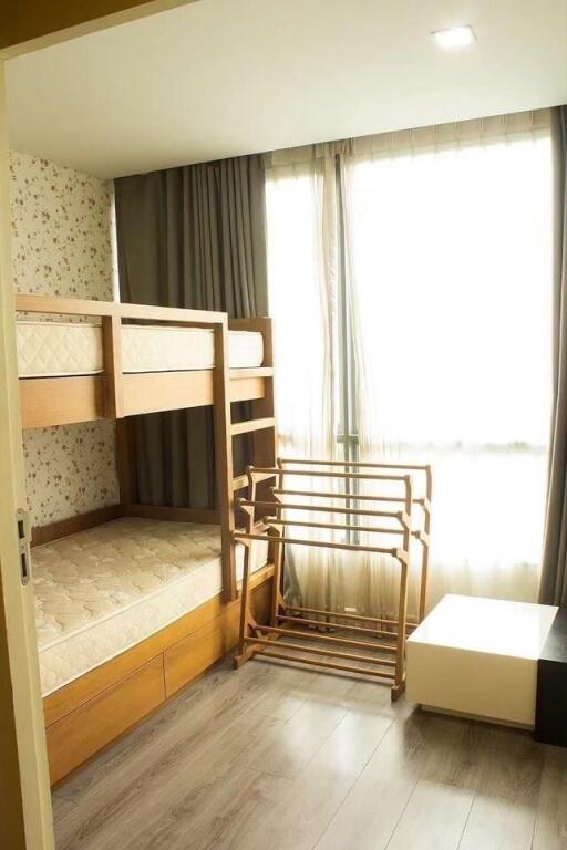 Bedroom with bunk bed and a drying rack near a window