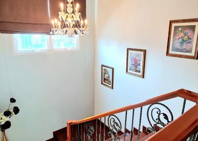 Elegant staircase with chandelier and framed artwork