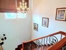 Elegant staircase with chandelier and framed artwork