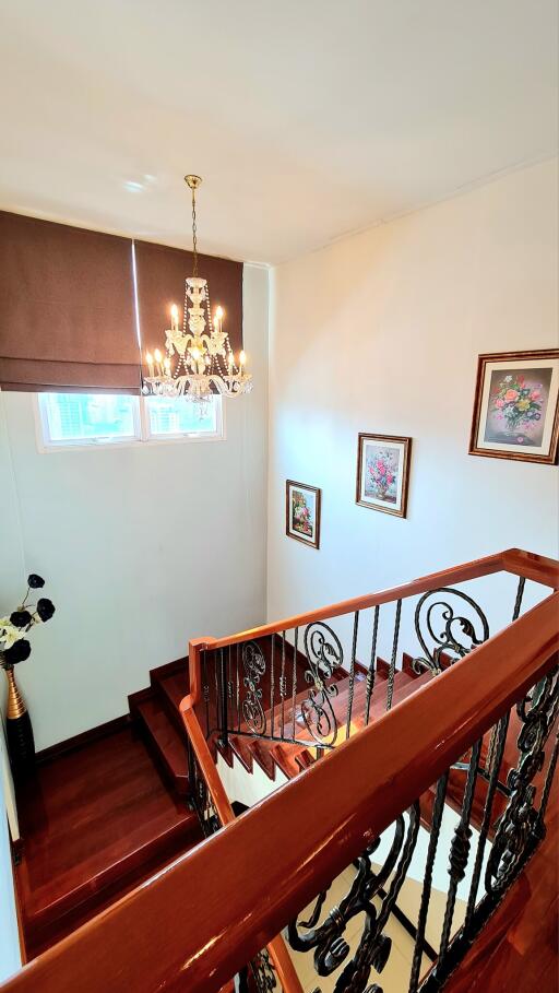 Elegant staircase with chandelier and framed artwork