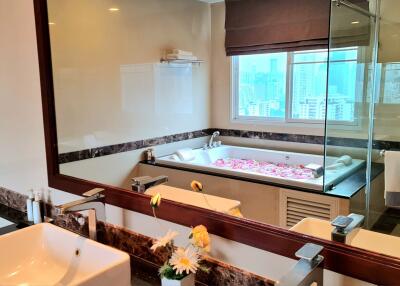 Modern bathroom with large mirror, bathtub, and double sinks