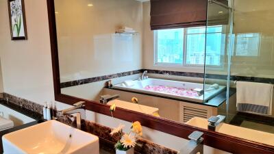 Modern bathroom with large mirror, bathtub, and double sinks