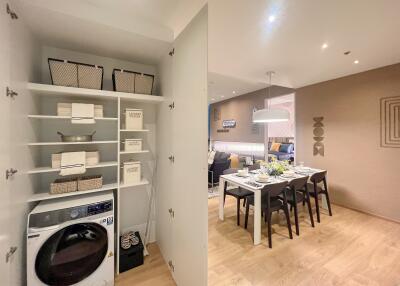 Laundry area with washer and storage next to a dining area