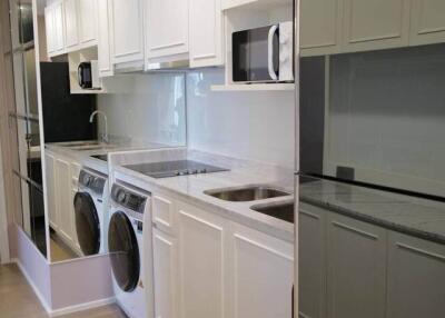 Modern kitchen with built-in appliances and washer-dryer