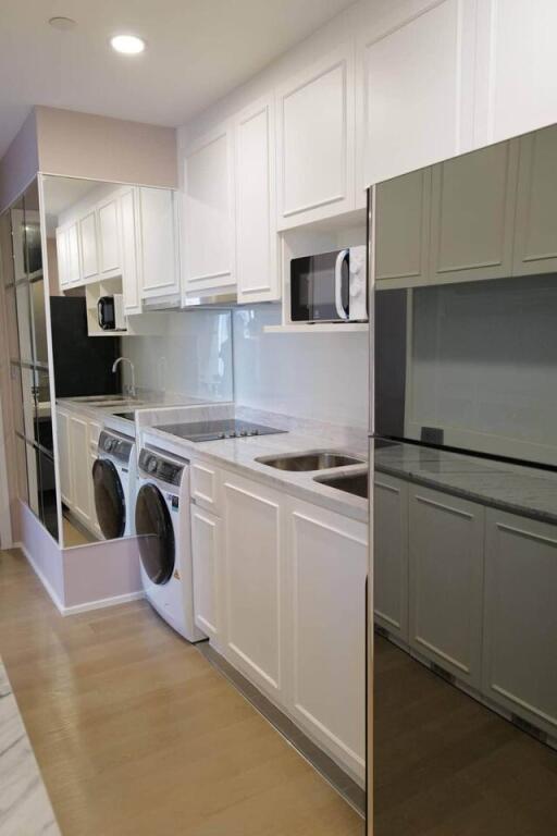 Modern kitchen with built-in appliances and washer-dryer