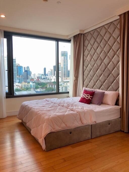 Spacious bedroom with a large window and city view