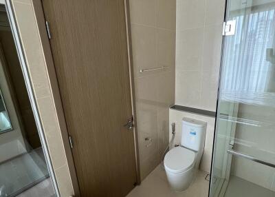 Modern bathroom with glass shower and wooden door