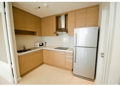 Modern kitchen with wooden cabinets, stainless steel appliances and white countertops