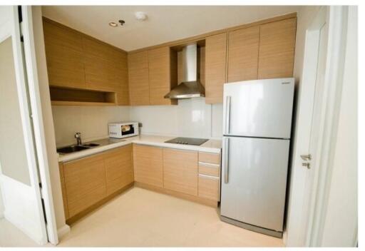 Modern kitchen with wooden cabinets, stainless steel appliances and white countertops