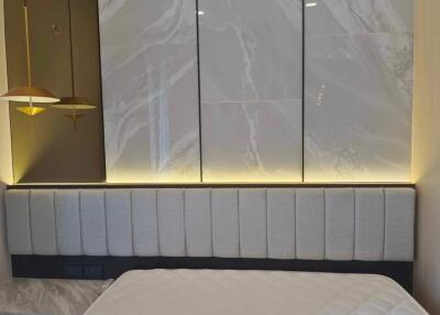 Modern bedroom with upholstered headboard and elegant lighting